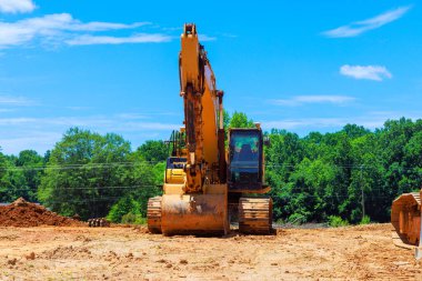 Güneşli bir günde, bir kazıcı şantiyede.