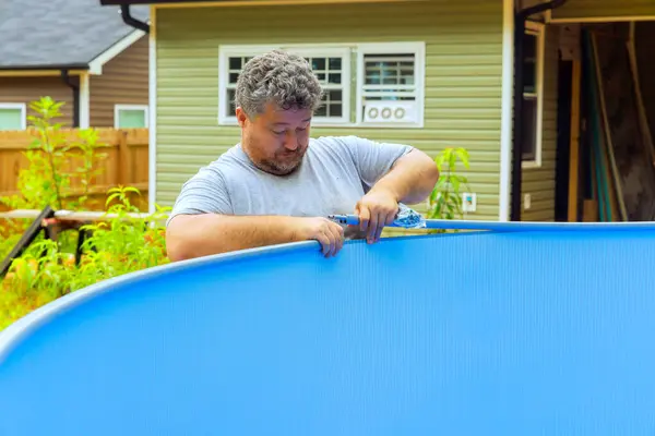 stock image Worker is engaged in installation of metal frame of aboveground pool