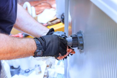 Bir kurulum teknisyeni havuz çerçevesine su filtreleme sistemi, klor sistemi kurar