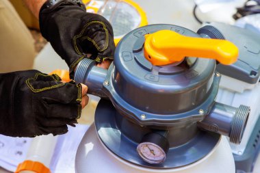 Havuz bakıcısı, yüzme havuzu temizlemek için kum filtresi sistem tankı ekipmanı monte eder