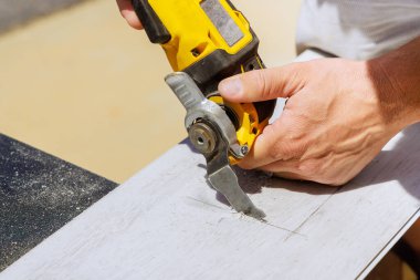 İşçi bir çıkış için kaplama panelinde delik açmak için çoklu aracı kullanıyor