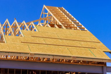 Under construction, wooden roofing trusses are installed on roof of house clipart