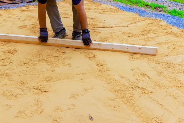 stock image Using level for leveling sand when preparing platform for installation of swimming pool in backyard