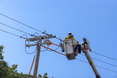 Yüksek voltajlı elektrik hattında çalışan bir elektrikçi servis için yalıtılmış sepet kullanır.