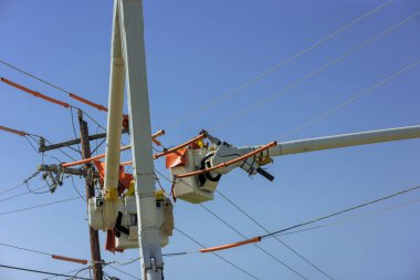 Hat görevlisi elektrik hattında hizmet verebilmek için direğe tırmanırken yalıtımlı ekipman kullanıyor.