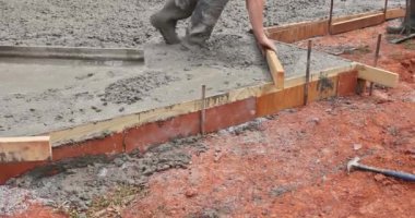 İnşaatın temeli üzerine beton döşeyen işçiler