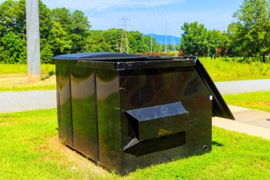 At construction site, waste is collected in metal containers clipart