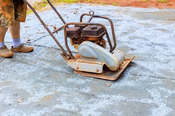 stock image Vibratory tamping machine compacting sand during construction of pool platform