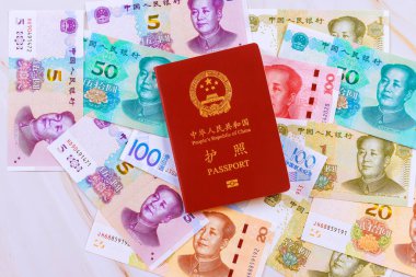 Çin Halk Cumhuriyeti tarafından verilen pasaporta nakit para ve çeşitli banknotlar eşlik etmektedir.