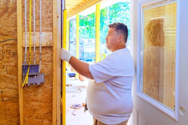 İnşaat şirketinin bir çalışanı kurarken sarı ruh ölçüsü seviyesinde yeni bir ön kapı kullanır.