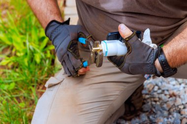 Tesisatçı, su tedarik sistemine bağlamadan önce plastik muslukları birbirine bağlar.
