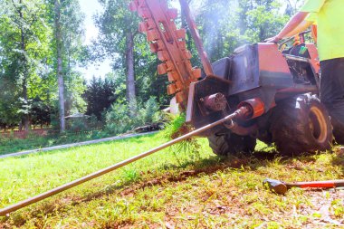 Using horizontal directional drilling machine to lay trenchless communications fiber optics before installing an underground cable clipart