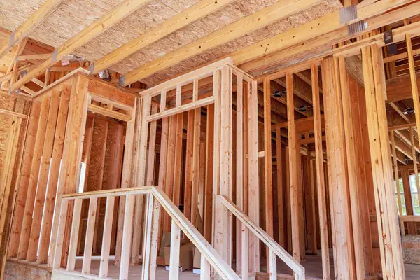 stock image An unfinished interior of newly constructed house beam is supported by wooden stud timber framing