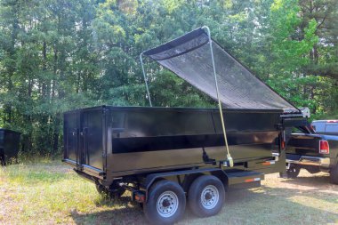 At recycling center, truck lorry unloads container of construction waste clipart