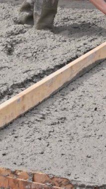 İnşaat sahasında, duvar seviyeleri temel için betonu tarıyor