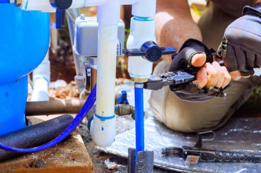 Tesisatçı evdeki su kuyusuyla su bağlantısını birleştirir