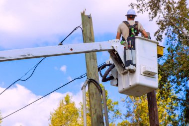 Kamyona monte edilmiş hidrolik kule kovası kullanılarak elektrik hattı direklerine onarımlar yapılıyor..