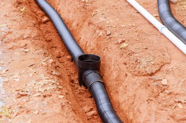 Açık siperlerde fırtına suyu drenajı için drenaj boruları döşenir.