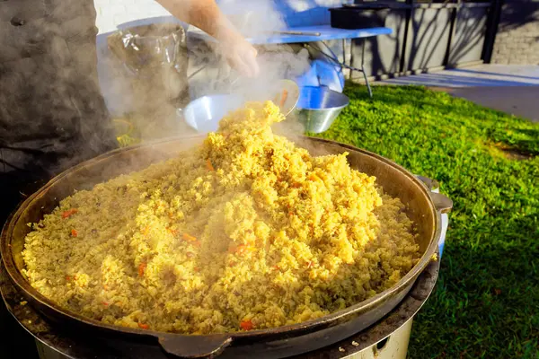 Büyük dökme demir kazan, geleneksel yemek pişirme sırasında Türk pilavı