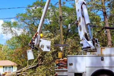Kasırgadan sonra, teknisyen kova kaldırma ile elektrik direği üzerinde çalışır.
