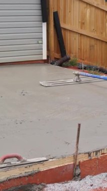 İnşaat sahasında, mason seviyeleri uzun mala kullanarak temel için beton tarama
