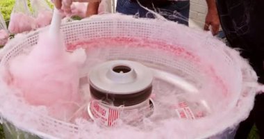 Lezzetli ikram dışarıda hazır. Pembe pamuk şeker yapmak için makina tavası kullanılıyor.