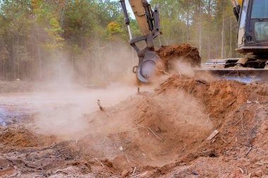 İnşaat alanında, bir kazıcı Dünya 'yı çöp kamyonuna taşımak için kullanılır.