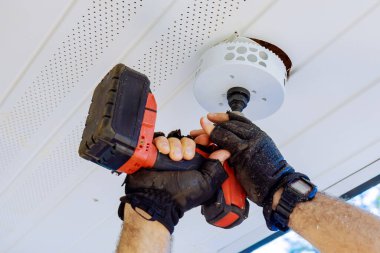 Kablosuz matkap kullanılarak yeni bir ışık armatürü kurulumu için tavan hazırlanıyor