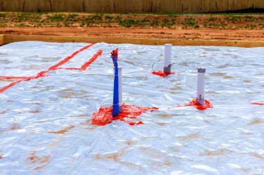 İşçiler inşaat sahasına plastik döşeme boruları döşeyerek vakıf çalışmalarına hazırlanıyorlar