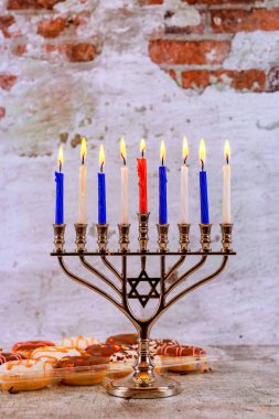 Ahşap masada dinlenen dokuz mumlu Hanuka menorası Yahudi bayramının ışığını simgeler.