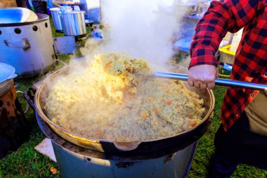 Geleneksel Türk pilavı büyük dökme demir kazanda pişirilirken mutfak hazırlanıyor