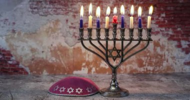 Dokuz mum yakan Menorah, Yahudi bayramı bayramı bayramının ahşap masasında dinlenen kippah ışığı simgeliyor.