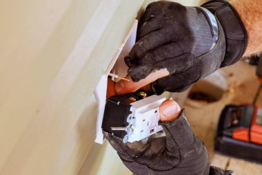 Evin dış cephesine bir elektrikçi tarafından prizler yerleştirir.