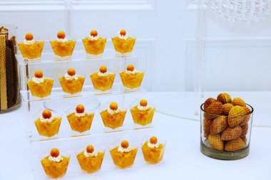 Rafine tatlı aranjmanları portakallı kurabiyelerin üzerine krema doldurulmuş küçük bardaklar kutlama için mükemmel..