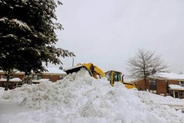 Kar küreme aracı, kış günü evlerle çevrili yerleşim alanındaki sokaktan derin karları aktif olarak temizliyor...