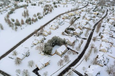 Sersemletici kar Amerikan banliyö manzaralarını kapladı. Açık binalar, yollar, sakin kış ortamında dağınık ağaçlar.
