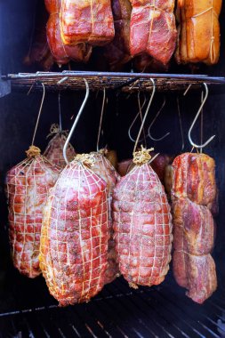 Tütsülenmiş etlerle dolu sigara içen kancalardan sarkan domuz pastırması tütsüleme evinde leziz bir aşçılık geleneği yapmak için birleştirilir.