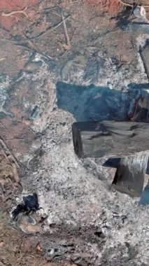 Yanmış kütükler, kül kontrollü yanıktan sonra kalır, kararmış odunlar sergilenir, duman kalıntıları..