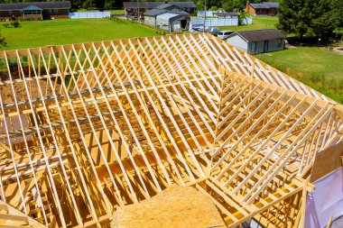 Ayrıntılı görünüm, yapım aşamasında olan ahşap çatı çerçevesini çerçeve oluşturmayla meşgul olarak gösterir