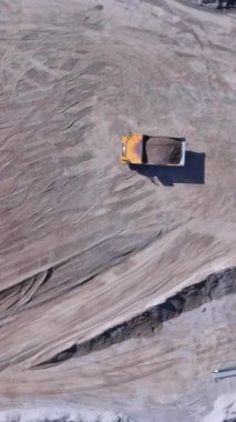 Yerdeki ağır makineler uzak bölgedeki inşaat sahasında toprak şekillendirme yapıyor..