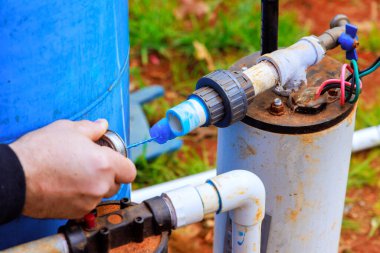 İşçi PVC boru tesisatı su kuyusu sistemine bağlanarak, yeni evin yakınındaki temiz su erişimini sağlıyor