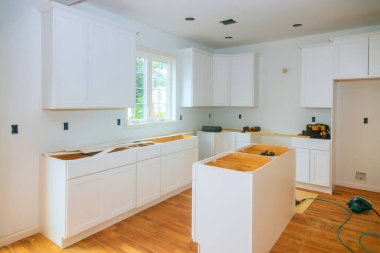 Ev yenileme projesi sırasında dolaplar doğal ışıkla dolu geniş bir mutfağa yerleştiriliyor.