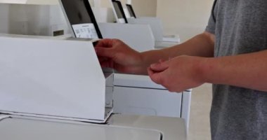 Birisi çamaşırhanedeki çamaşır makinesine bozuk para koyar, öğleden sonra güneşinde çamaşır hazırlar..