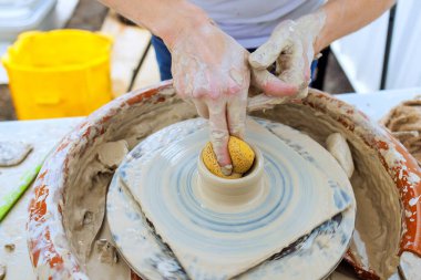 Potter hands mold clay on pottery wheel in an outdoor workshop, highlighting creativity under works clipart