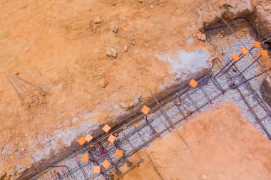 İşçiler inşaat alanındaki inşaat sahasının temelleri için demir döşüyorlar, çakıl döşüyorlar.