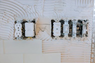 Çoklu elektrik prizleri, ev yenileme çalışmaları sırasında desenli duvara şalter monte ediliyor.