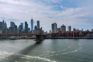 Brooklyn Köprüsü, New York Amerika 'daki Manhattan siluetinin arkaplanıyla Doğu Nehri' ni kaplıyor.