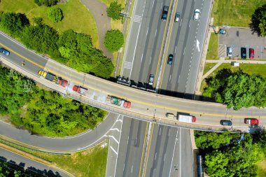 Araçlar New Jersey 'deki varoş Amerikan kasabasının kenar mahallelerinde yemyeşil ağaçlarla dolu çoklu şeritli yollarda yol alıyorlar.