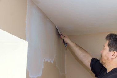 Marangoz duvar köşesini alçıyla ustalıkla bitiriyor, ev geliştirmeye odaklanıyor.