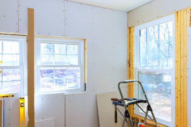 İyi ışıklandırılmış alana yerleştirilen pencerelere alçıpan döşendiği için inşaat devam ediyor.